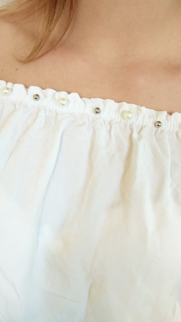 Bílá halenka s perlami u výstřihu